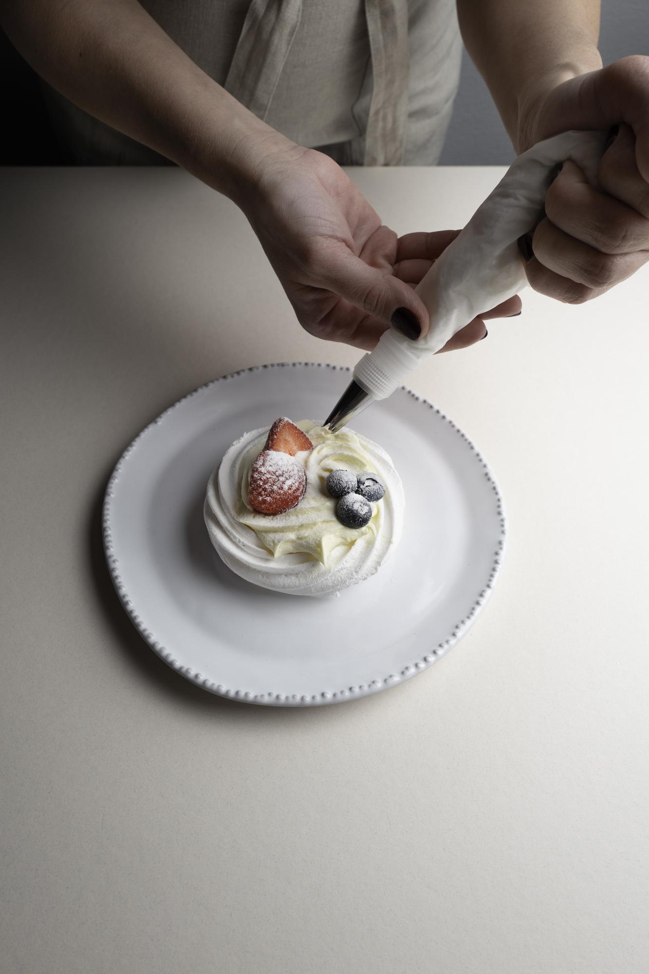 Hands plating dessert in studio